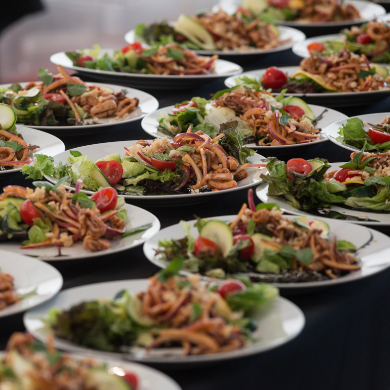 plated salads spread out on table, ready for service