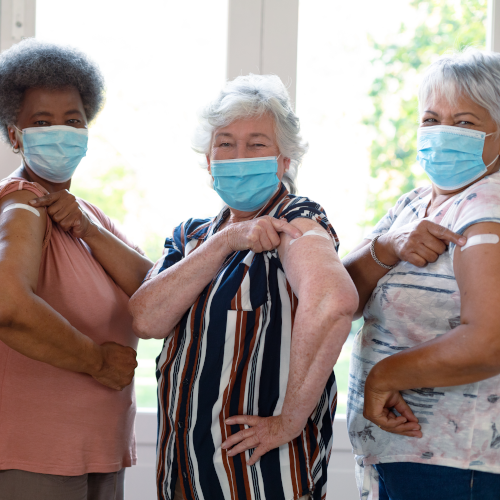 elderly women showing off bandaids from vaccination