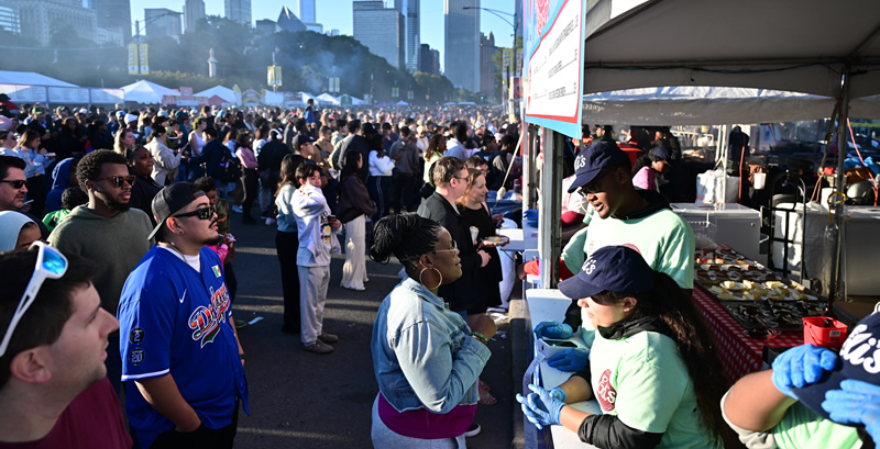 Taste of Chicago crowd and food vendor tents on street with skyline in the background