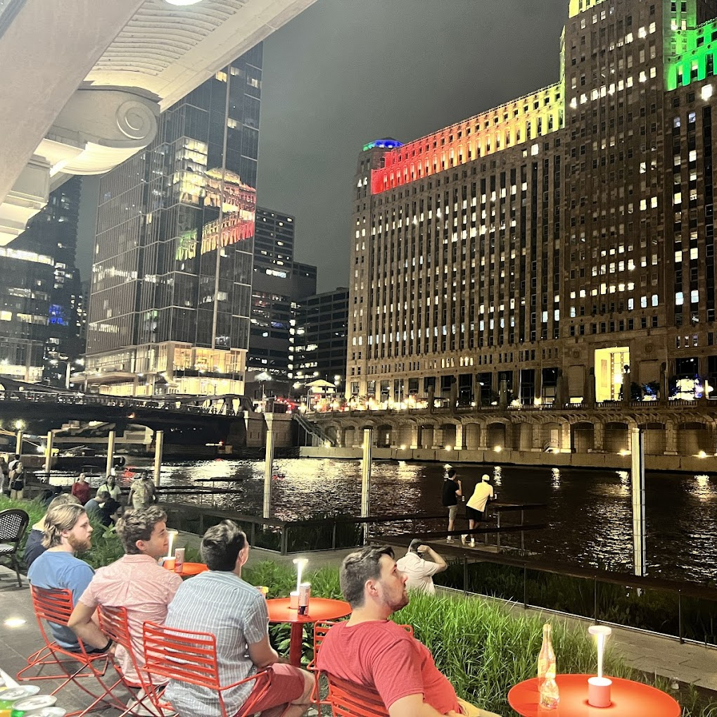 Diners enjoying the scenery at night by the Chicago River.