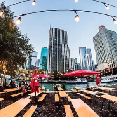 People seated at tables along the Chicago river