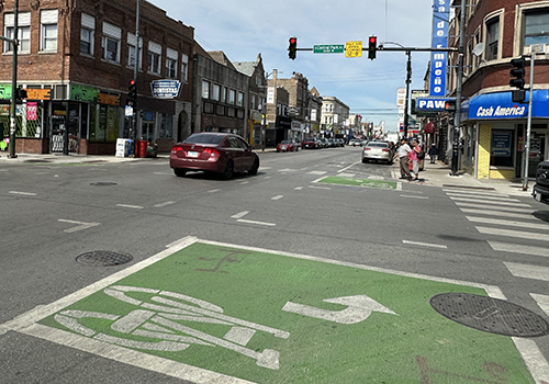 view of intersection with two green boxes containing bike symbols and arrows