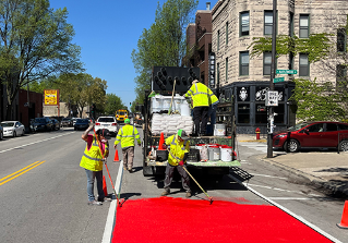 Construction crew painting a red bus lane