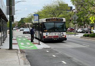 Person waiting at a bus stop with a CTA bus approaching