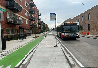 CTA bus stopped at bus stop with a concrete bus boarding island separating the travel lane from green painted bike lane.