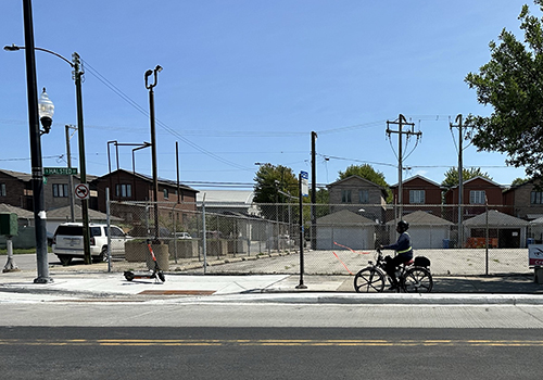 View of person cycling in a bike lane with concrete separating the bike lane from motor vehicle traffic.