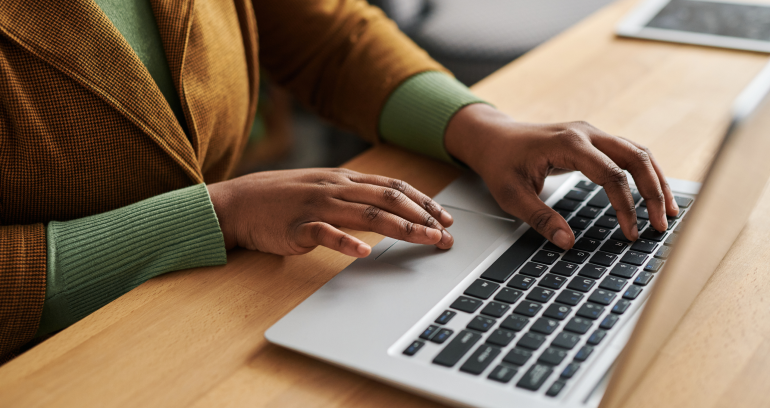 hands typing on a laptop keyboard