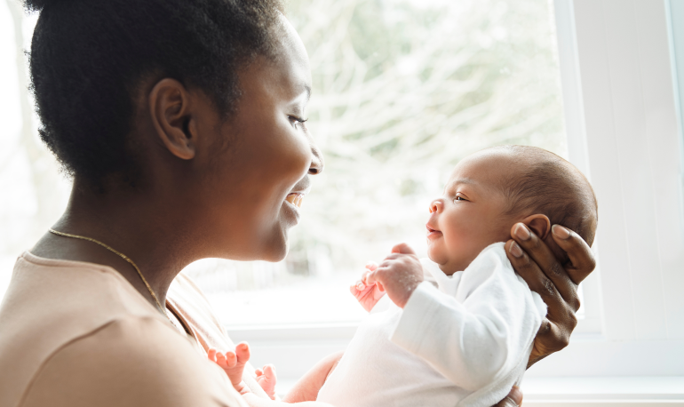 Woman holding a baby and smiling at it